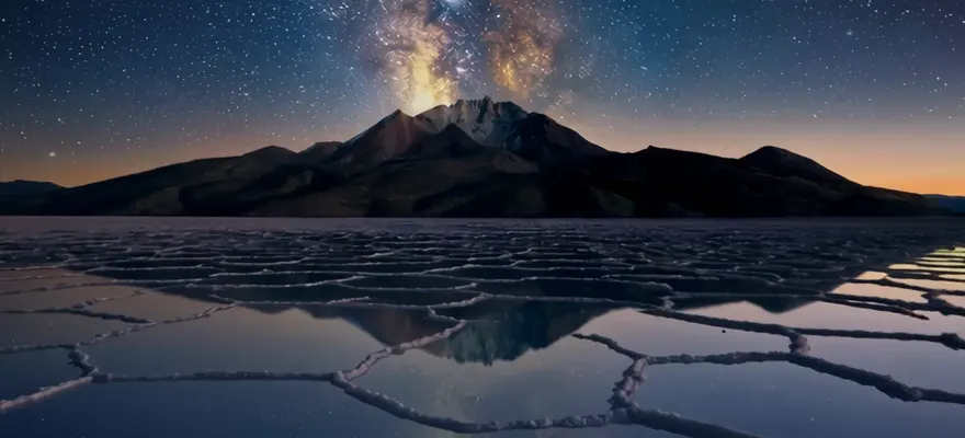 El volcán Thunupa bajo la Vía Láctea, reflejado en el salar
